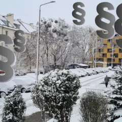 Zimowy krajobraz miejski z symbolami paragrafu.
