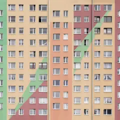 Wielopiętrowy blok mieszkalny z kolorowymi pasami. Co to znaczy mieszkanie spółdzielcze własnościowe? To prawo do lokalu, ale nie do gruntu.