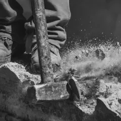 Młot rozbija beton, tworząc chmurę pyłu. To może być kara za wyburzenie ściany nośnej.
