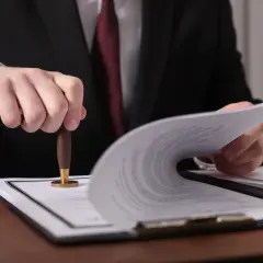 Prawnik pieczętuje dokumenty. Czy od spadku po rodzicach płaci się podatek? Dowiedz się, jakie są zasady.