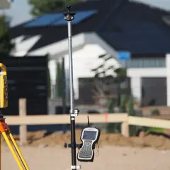 Geodeta sprawdza przy odbiorze budynku położenie elementów za pomocą tachimetru i odbiornika GPS.