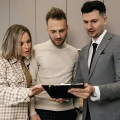 Para omawia z agentem nieruchomości dokumenty dotyczące obowiązków wynajmującego mieszkanie.