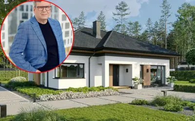 Mężczyzna w garniturze obok nowoczesnego domu. Pomoc w formalnościach związanych ze sprzedażą domu.