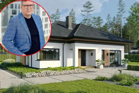 Mężczyzna w garniturze obok nowoczesnego domu. Pomoc w formalnościach związanych ze sprzedażą domu.