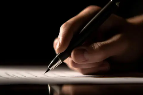 Dłoń pisze długopisem. To może być wezwanie do usunięcia wad przez dewelopera wzór.