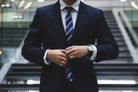 Biznesmen zapina marynarkę. Czy rada nadzorcza może odwołać prezesa? Pytanie o władzę w korporacji.