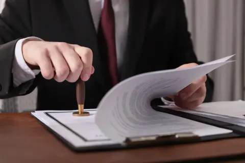 Prawnik pieczętuje dokumenty. Czy od spadku po rodzicach płaci się podatek? Dowiedz się, jakie są zasady.