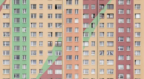 Wielopiętrowy blok mieszkalny z kolorowymi pasami. Co to znaczy mieszkanie spółdzielcze własnościowe? To prawo do lokalu, ale nie do gruntu.