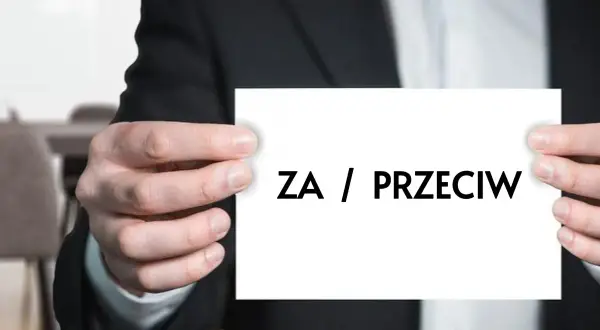 Mężczyzna w garniturze trzyma kartkę z napisem "ZA / PRZECIW". Dylemat, kiedy uchwała wspólnoty mieszkaniowej jest nieważna.