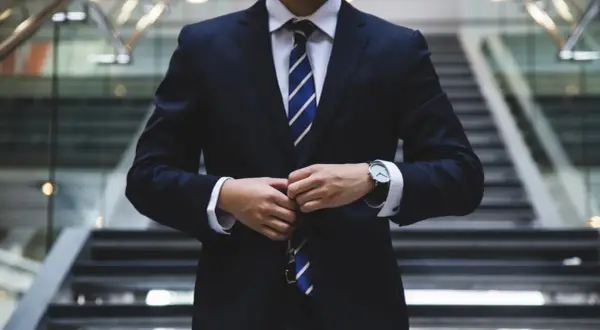Biznesmen zapina marynarkę. Czy rada nadzorcza może odwołać prezesa? Pytanie o władzę w korporacji.