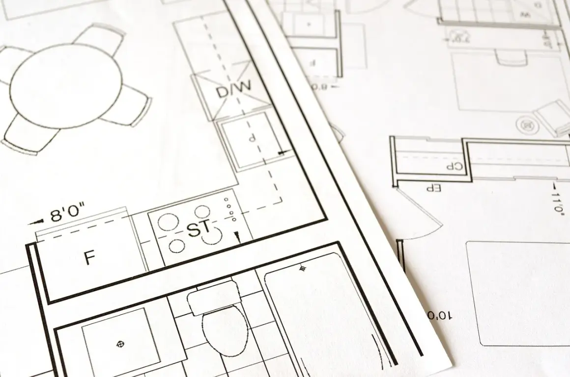 Plany architektoniczne ukazują adaptację projektu budowlanego, z zaznaczonymi kuchnią, łazienką i stołem.