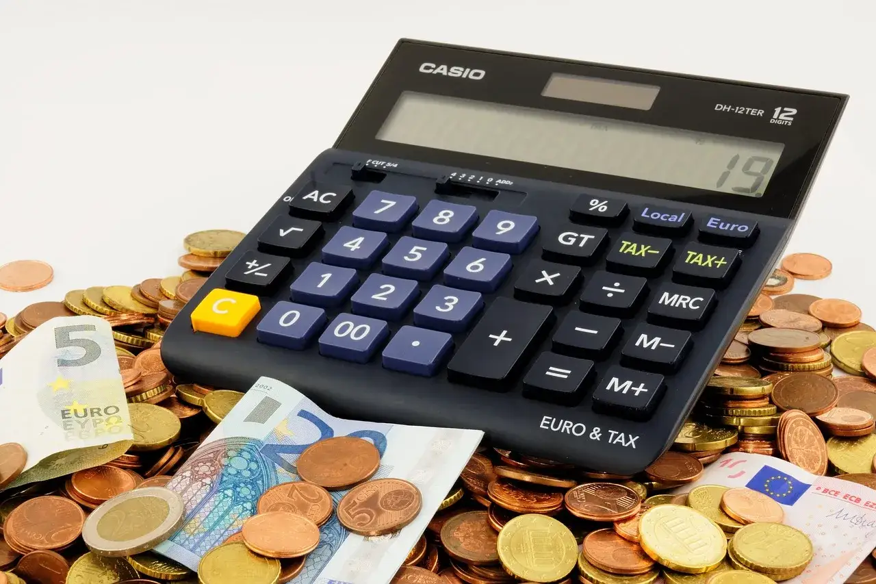 Kalkulator i monety euro. Obliczenia finansowe, w tym maksymalny wiek kredytobiorcy, są kluczowe.