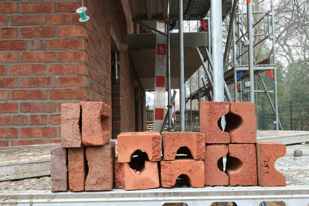 Stos cegieł na budowie, gdzie trwa budowa budynku. Prawo budowlane określa zasady wznoszenia takich konstrukcji.