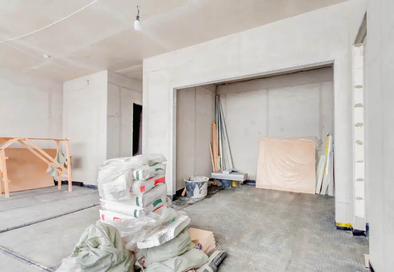 Materiały budowlane i rusztowanie wskazują na prace adaptacyjne, jak przekształcić budynek gospodarczy na usługowy.