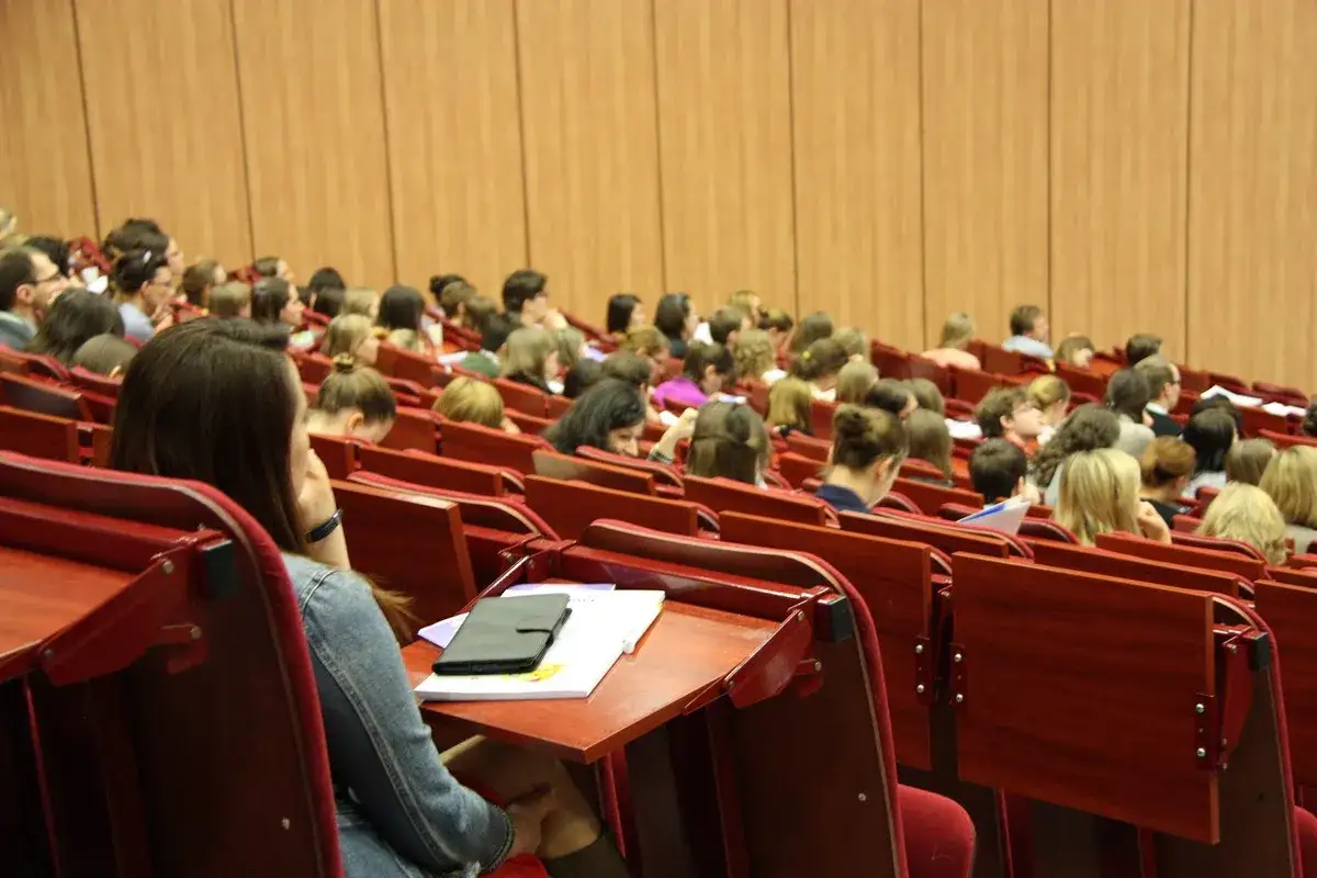 Studenci na wykładzie, zastanawiają się, czy wpisowe jest zwrotne.